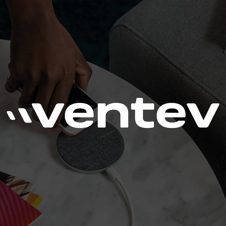 ventev logo overlaid on somone placing their phone on a wireless charger on a coffee table